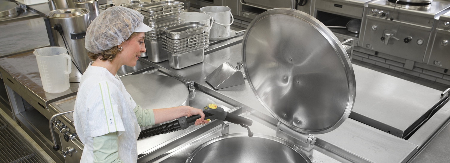 A person is cleaning kitchen utensils with a Kärcher steam cleaner