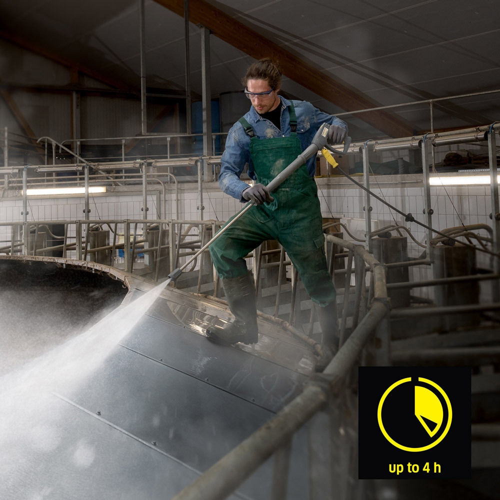 Go Cordless for Hours A worker pressure washes agriculture equipment in a barn.