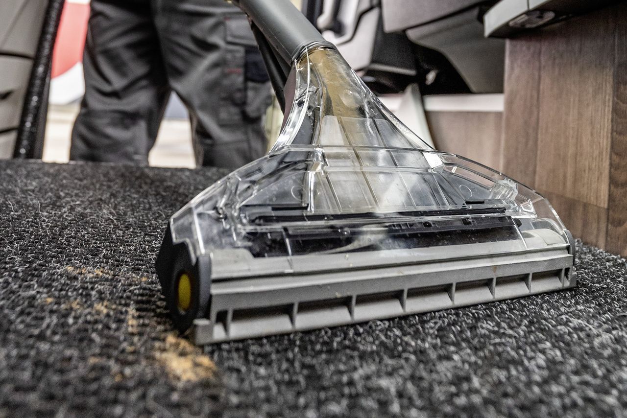 A close-up of a carpet extractor rinsing and sucking up dirty areas.