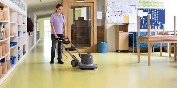 Classrooms A woman cleans a classroom floor with Kärcher cleaning equipment.