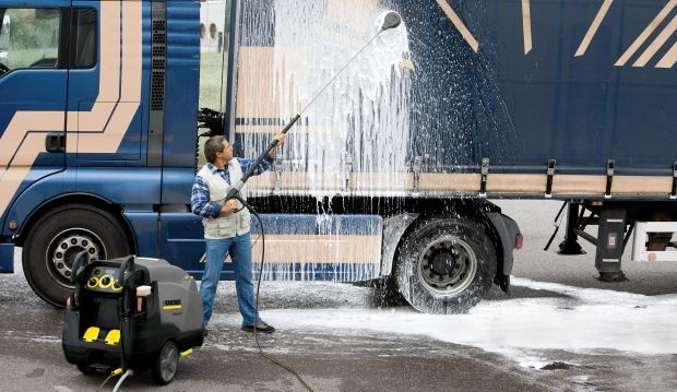 Trailers A man pressure washes a truck trailer.