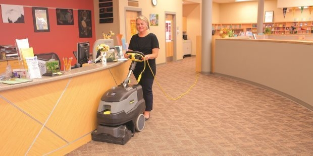 Libraries & Computer Labs A worker uses a compact walk-behind floor extractor to clean school library carpets.