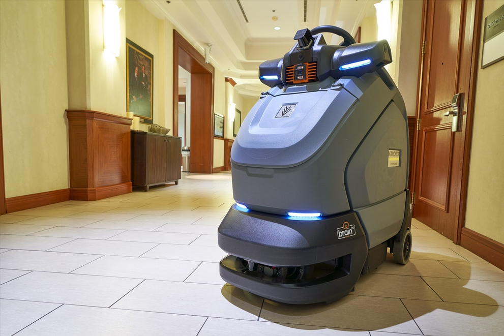 The KIRA CV 60/1 Stand-On Vacuum stands in a hallway.