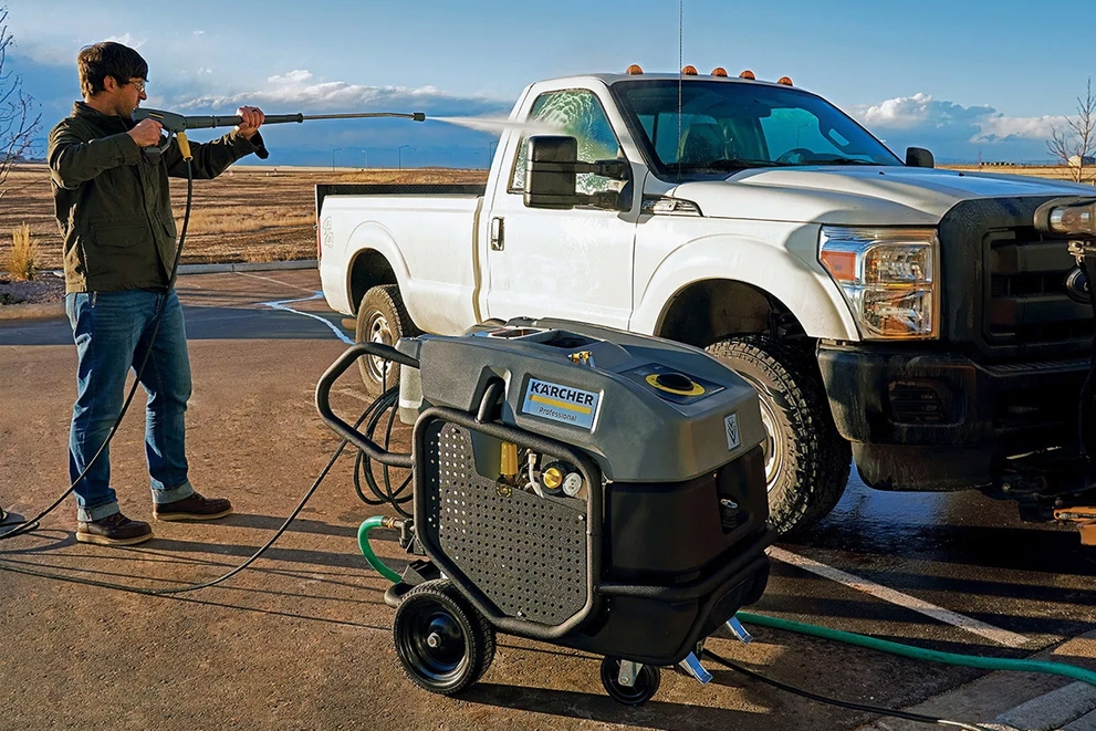 A worker cleans a company truck with a Mojave Electric Hot Water Pressure Washer