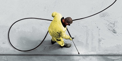 Aerial view of a man pressure washing a sidewalk