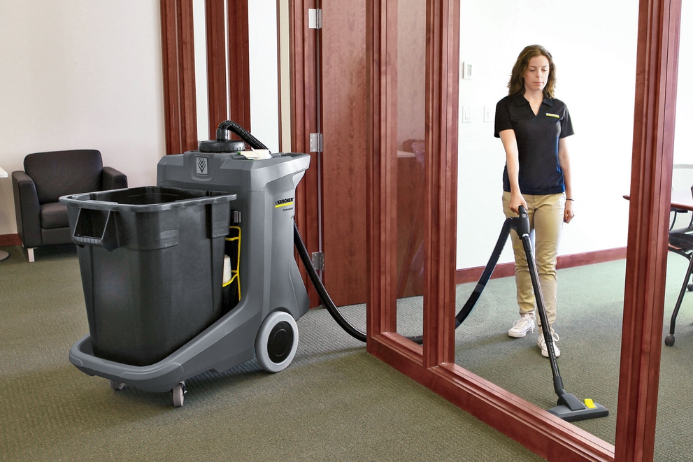 A worker uses a CartVac to clean corporate building offices.