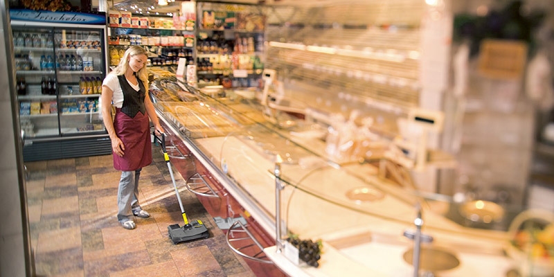 Cleaning in Bakeries A worker uses a compact walk-behind sweeper to efficiently clean inside a bakery