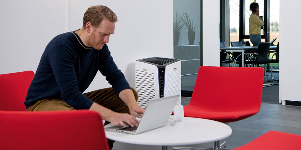 A man types on his laptop in an office