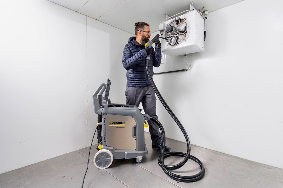 Efficiency for Economical Hygiene A man uses Karcher steam cleaner on a cooling fan.