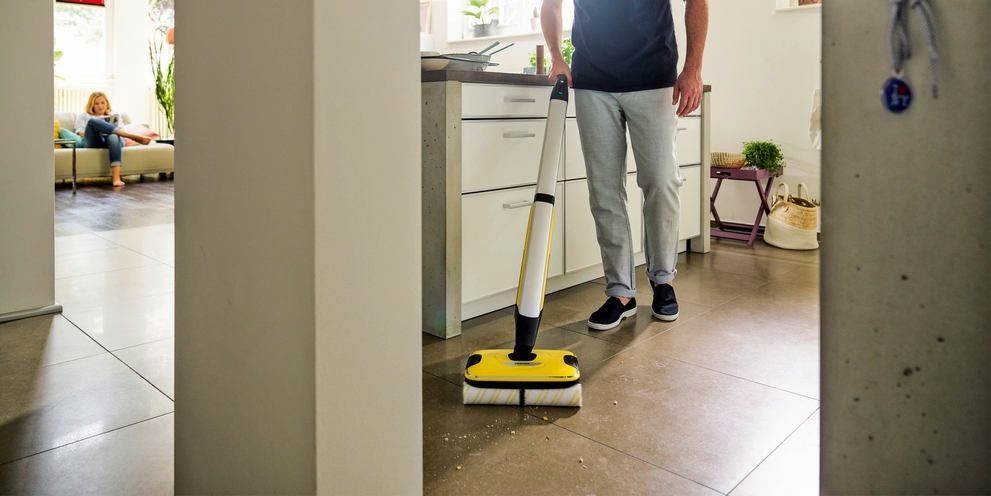 Man cleans floor with floor cleaners from Kärcher