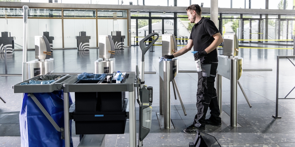 A worker manually cleans inside commercial buildings.
