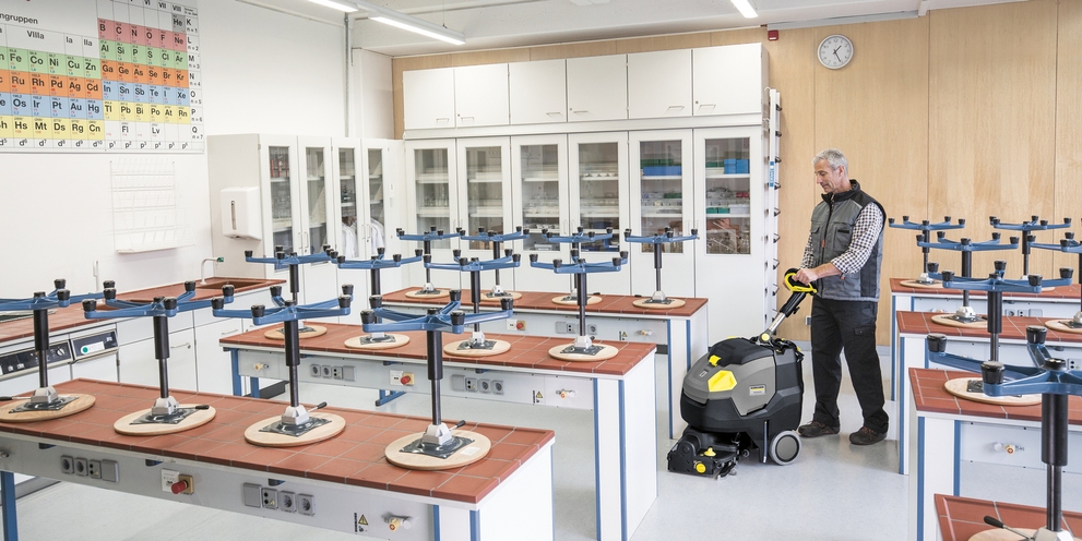 A worker cleans floors inside an educational institution.