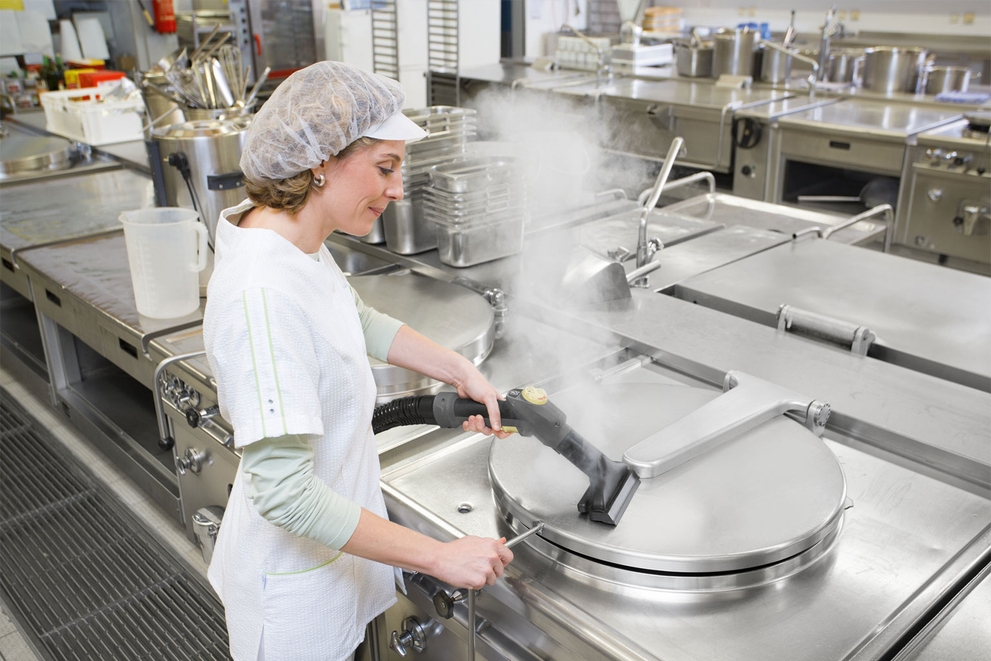 Hygienically Clean Woman using a Karcher steam cleaner on food service equipment.