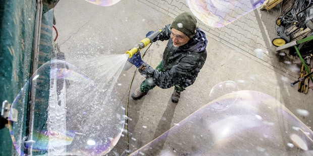 A photo of a man pressure washing.