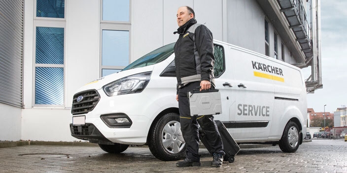 A Kärcher Services technician walks next to his service van.