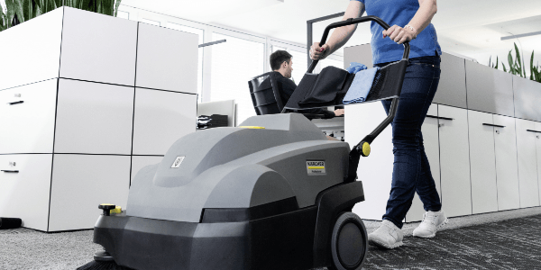 A worker sweeps quietly to avoid disrupting other coworkers.