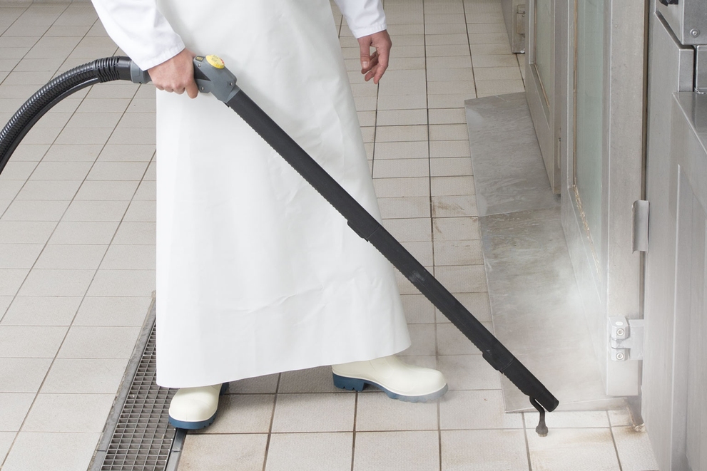 Steam Suction Wand and Adapter for Round Brushes Worker cleans commercial kitchen floors and appliances with a steam cleaner lance.