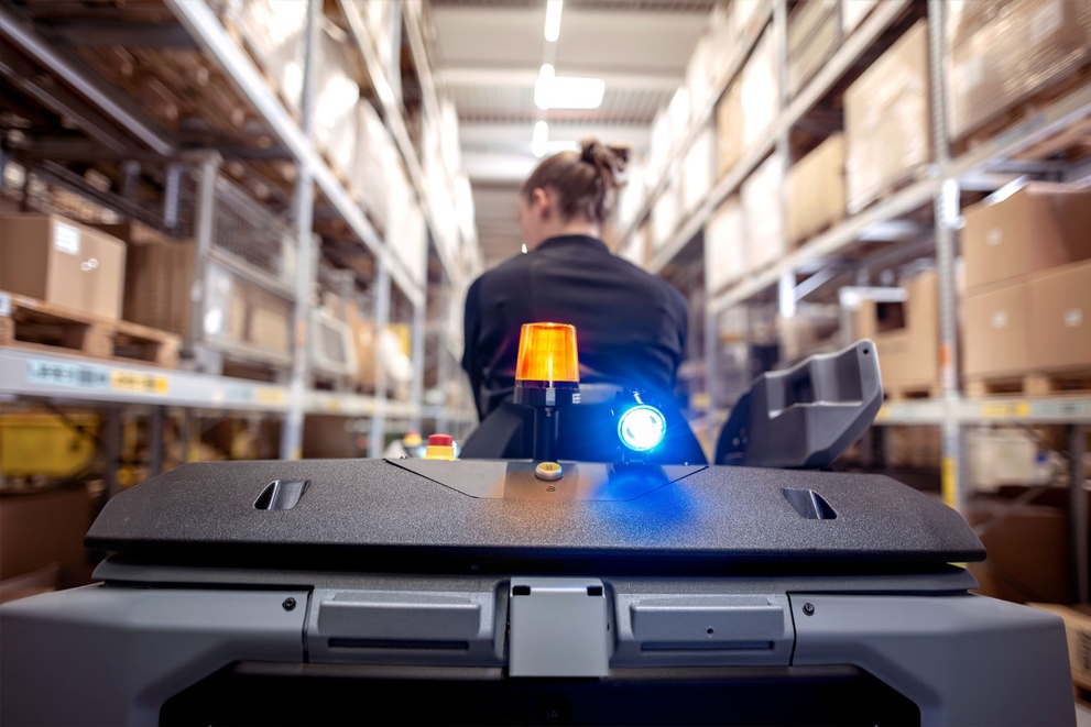 Unmatched Safety A worker rides on the KIRA B 200 to clean warehouse floors.