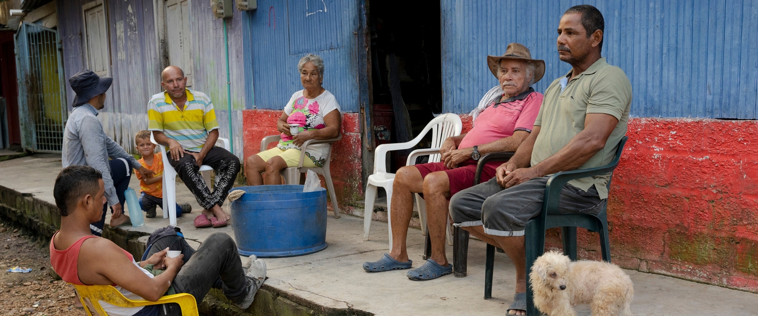 There is great solidarity among the residents in Bocas del Carare, everyone knows everyone. The picture shows a group of people sitting on plastic chairs in the sun. They are all residents of Bocas del Carare.