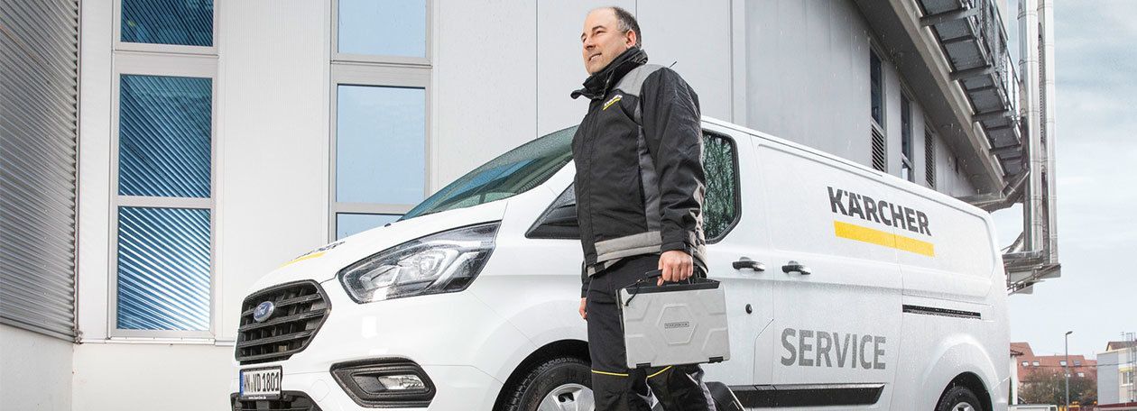 Kärcher Service-Mitarbeiter vor einem Auto