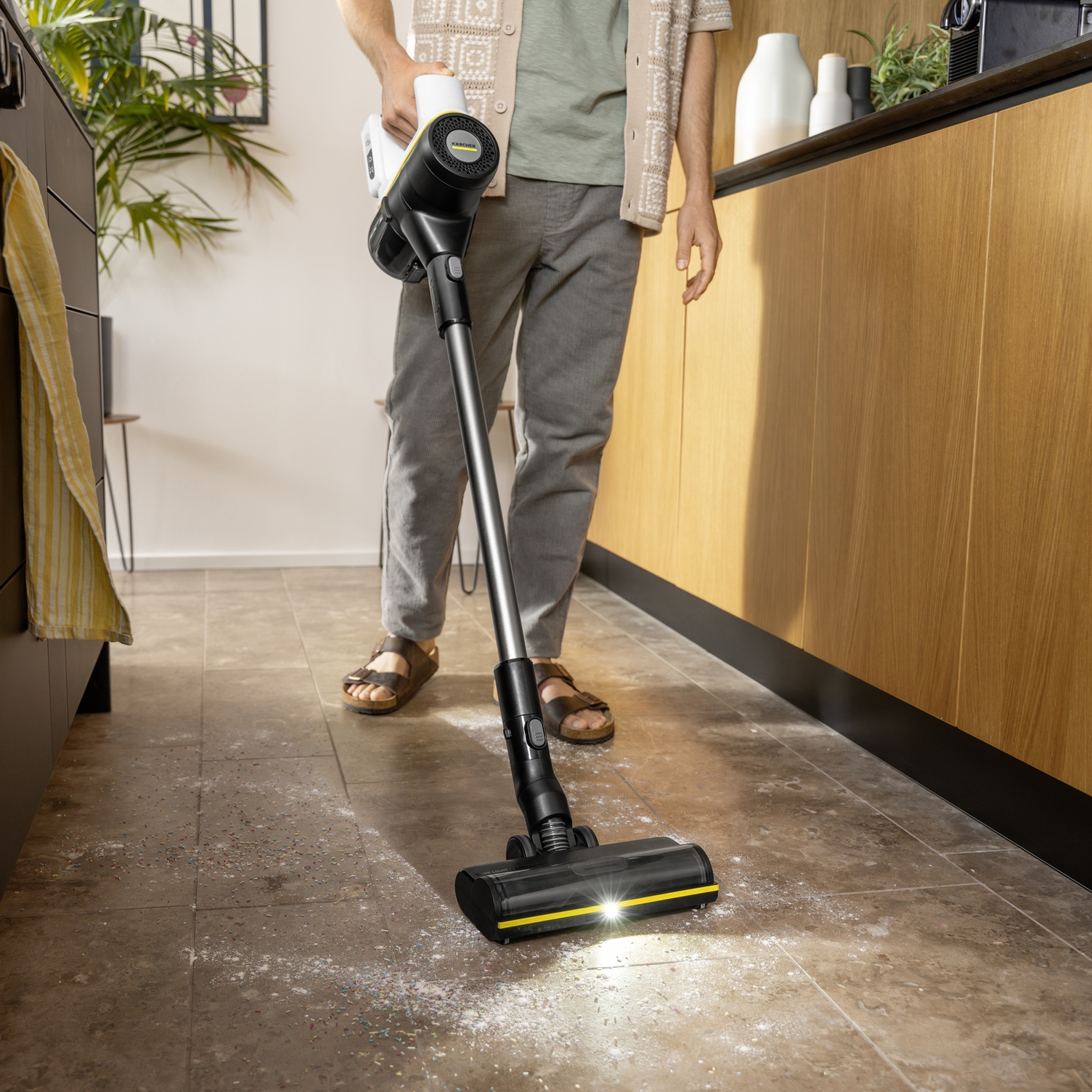 Patented floor nozzle for 100% dust pick-up Man efficiently vacuuming a hard floor with the Kärcher forward-and-reverse floor nozzle.