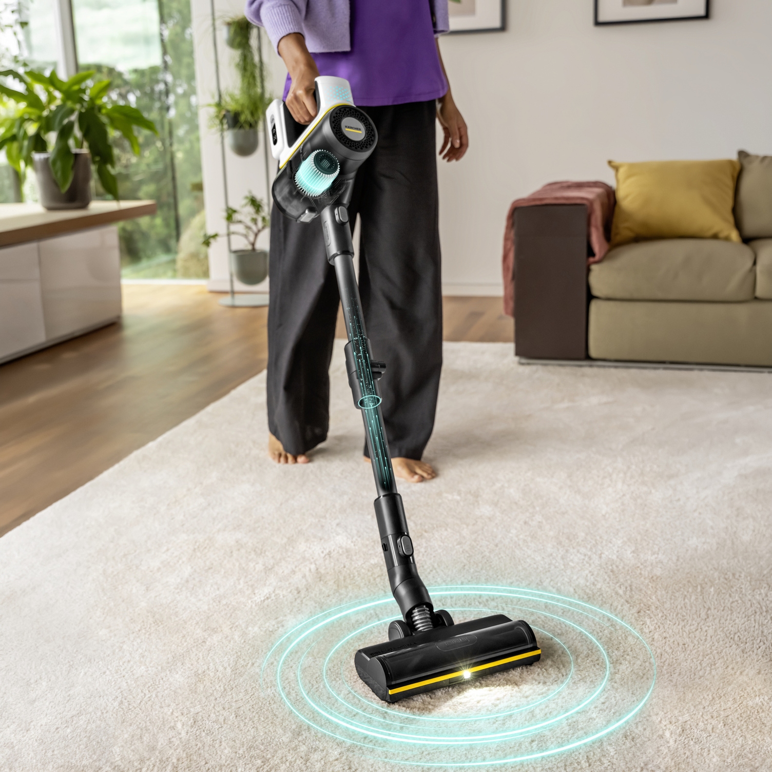 Kärcher VCS battery-powered vacuum cleaner with Smart Power technology for carpets Woman vacuuming a light-coloured carpet with a powerful Kärcher VCS battery-powered vacuum cleaner.