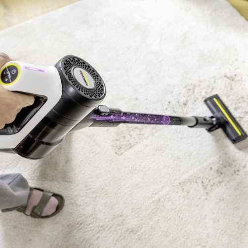 Auto-sense technology: automatic suction-power regulation Kärcher VCS 3 Nano battery-powered vacuum cleaner cleaning a light-coloured carpet with intelligent dirt detection.