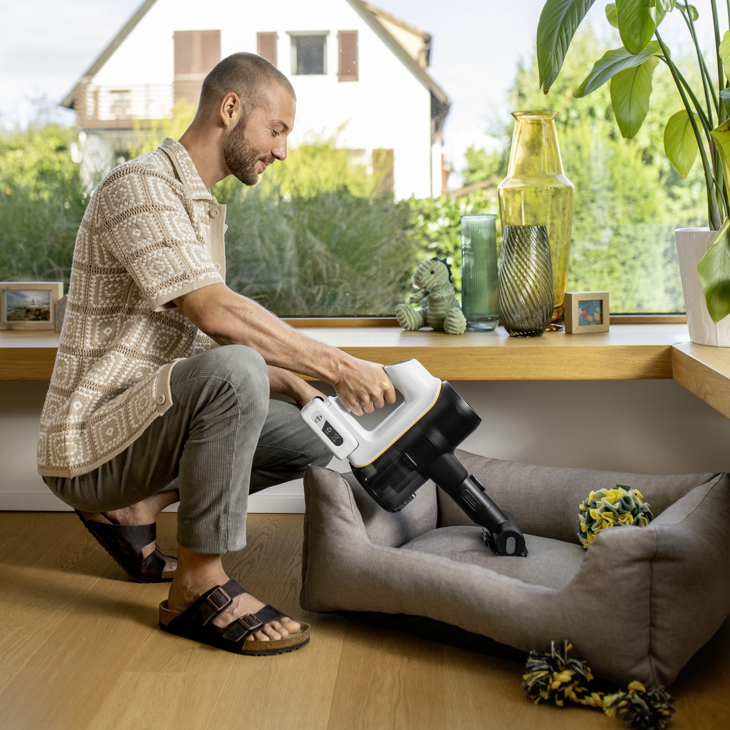 Kärcher handheld vacuum cleaner for quickly removing pet hair Man vacuuming pet hair from a dog bed with a compact Kärcher handheld vacuum cleaner.
