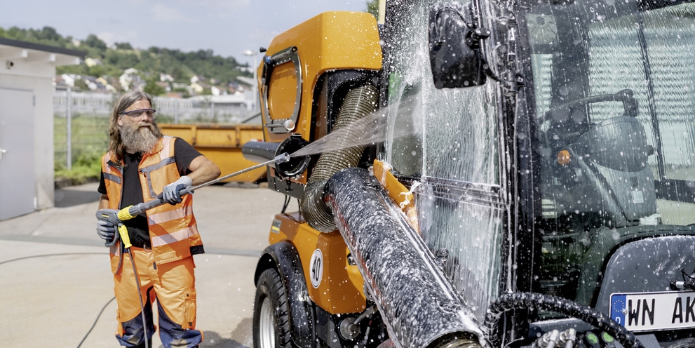 Public Services Man cleans municipal vehicle with high-pressure cleaner